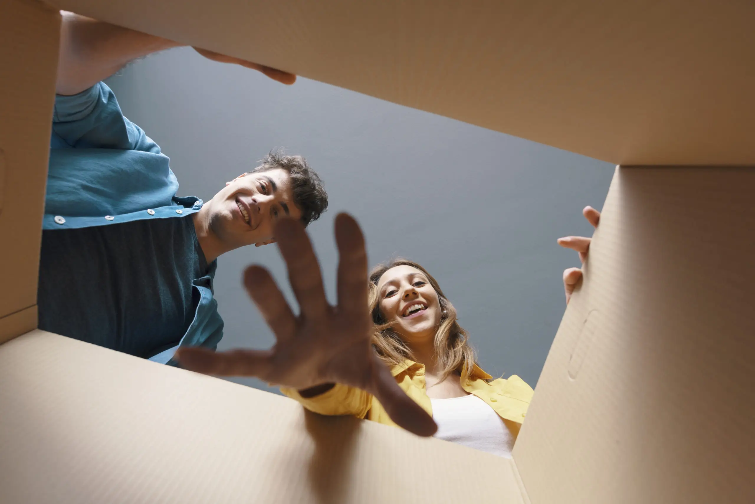 Glückliches Pärchen packt ein Paket aus.