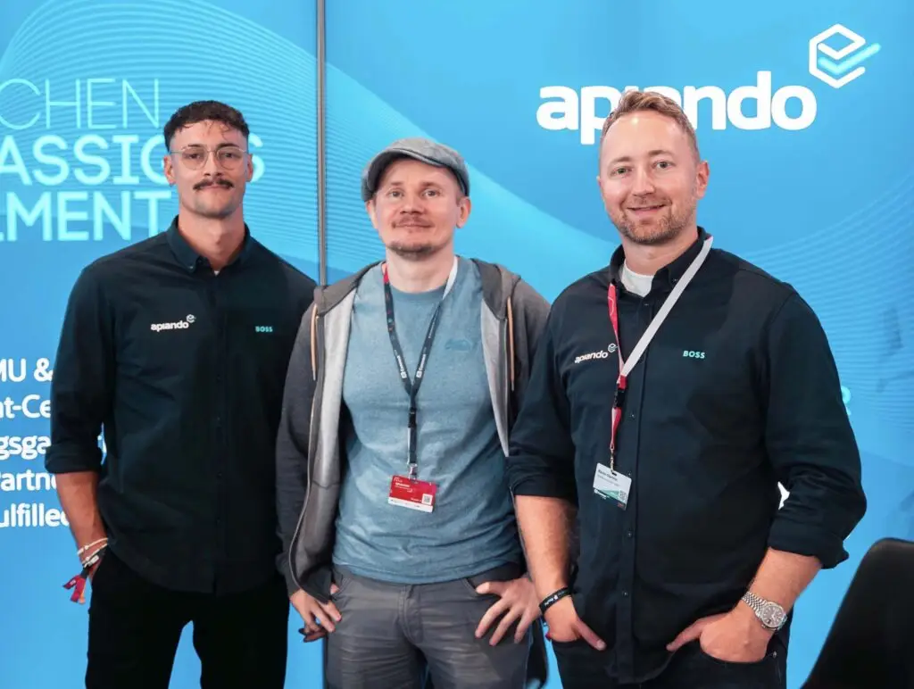 Drei Personen von Apiando – der COO, der JTL Founder und der CEO – stehen nebeneinander